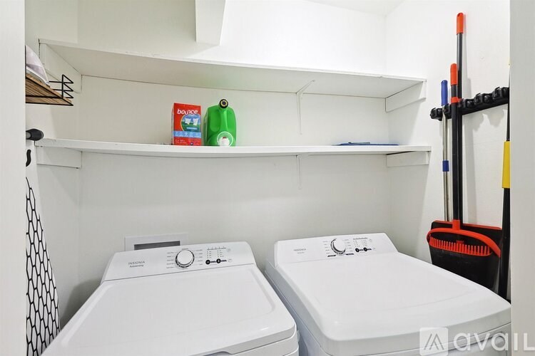 Two white washing machines in a small laundry room.