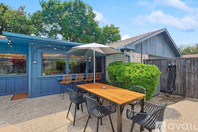 A patio with a table and chairs is set up outside a house.