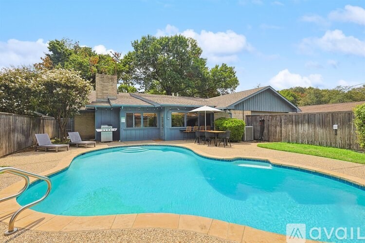 A pool in a backyard with a house in the background.