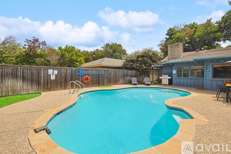 A pool with a blue tinted water and a wooden deck.