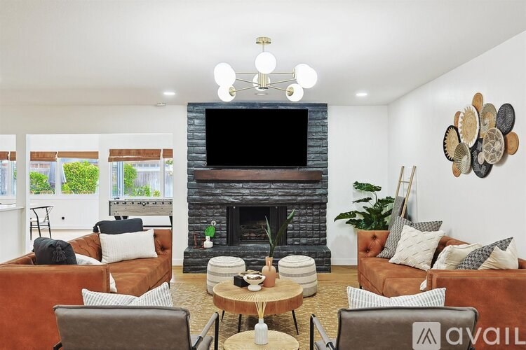 A living room with a fireplace and a flat screen TV mounted above it.