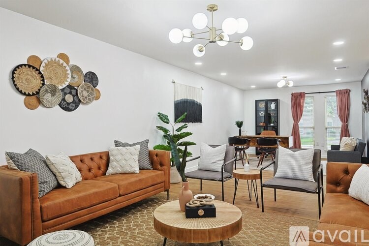 A living room with a brown sofa, a wooden coffee table, and a wall decoration of circular plates.
