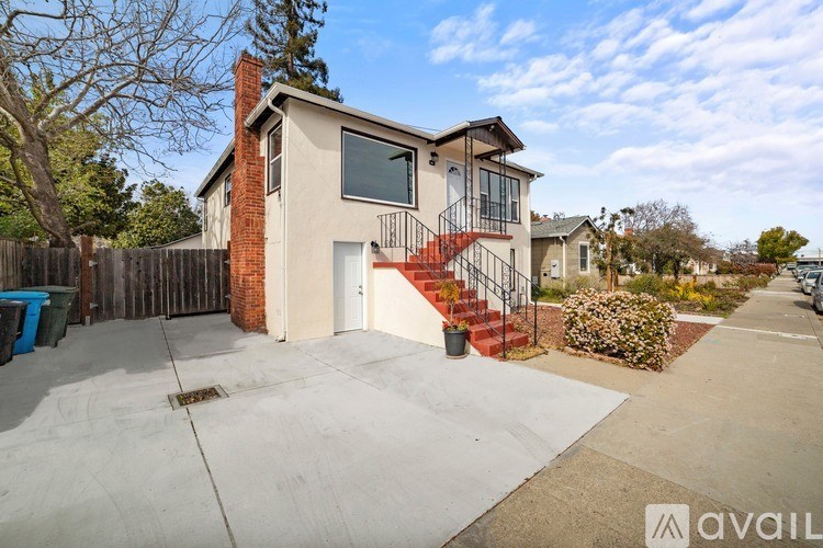 A two-story house with a red staircase and a white door is for sale.