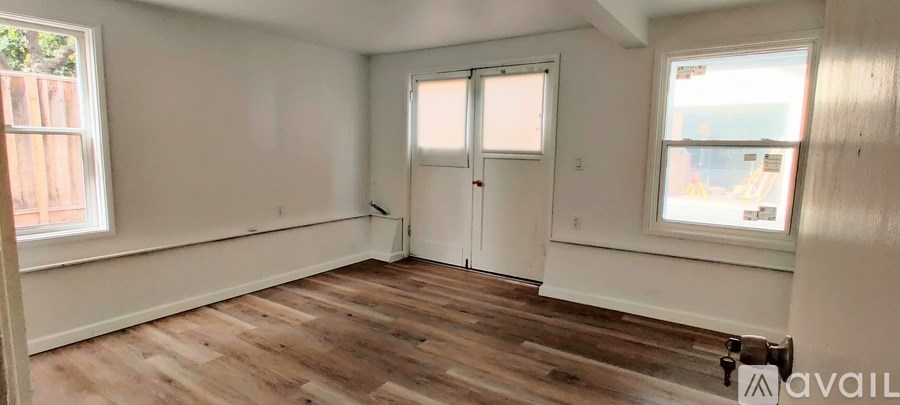 A room with wooden floors and white walls is available for rent or sale.