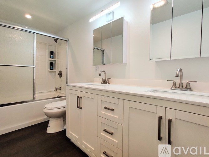 A bathroom with a toilet, sink, and mirror.