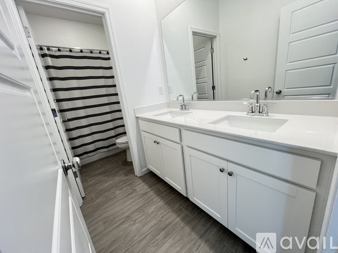 A white toilet in a bathroom with a striped shower curtain.