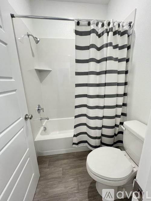 A bathroom with a toilet and a shower curtain.