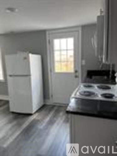 A kitchen with a white fridge and a black stove top.