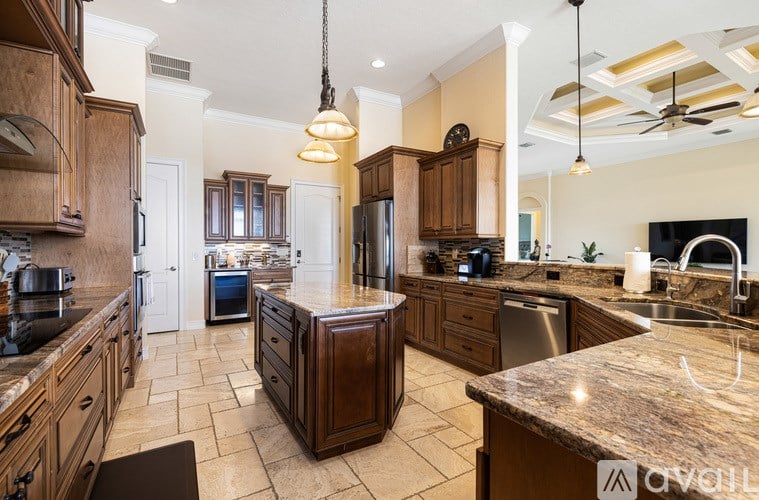 A kitchen with wooden cabinets and a marble countertop.