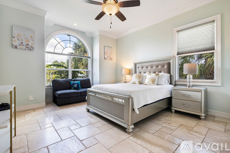 A bedroom with a large bed and a ceiling fan.