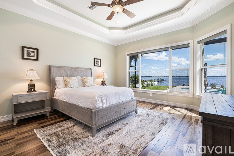 A bedroom with a large bed and a view of the water.
