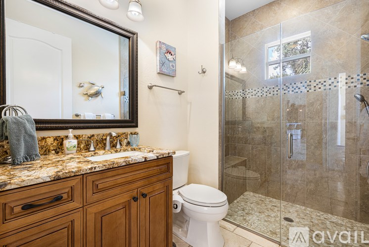 A bathroom with a toilet, sink, and shower.