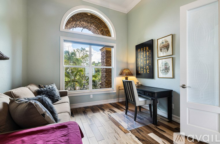 A living room with a couch, chair, and a desk.