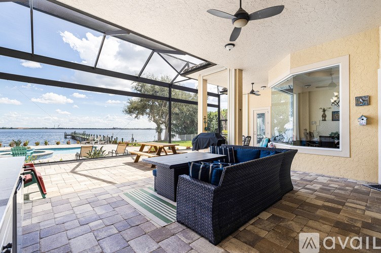A patio with a table and chairs overlooking a body of water.