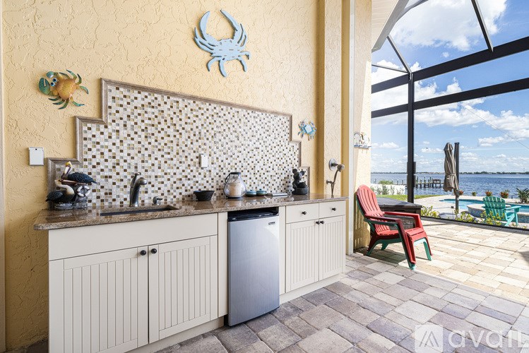 A kitchen with a sink and a window overlooking the sea.