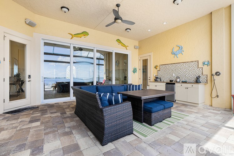 A living room with a couch and a ceiling fan.