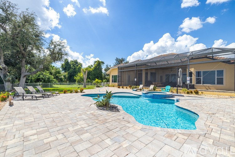 A swimming pool surrounded by a patio and a house.