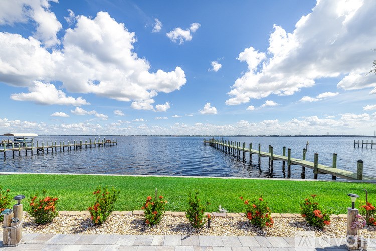 A serene waterfront scene with a dock and lush greenery.