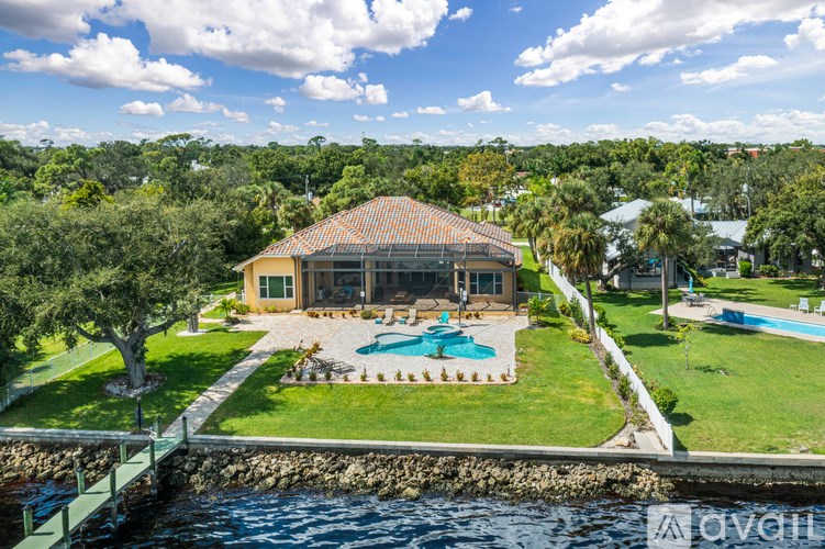 A house with a pool and a bridge over water.