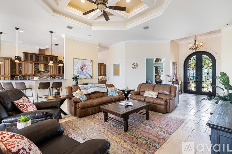 A living room with a ceiling fan and a rug on the floor.