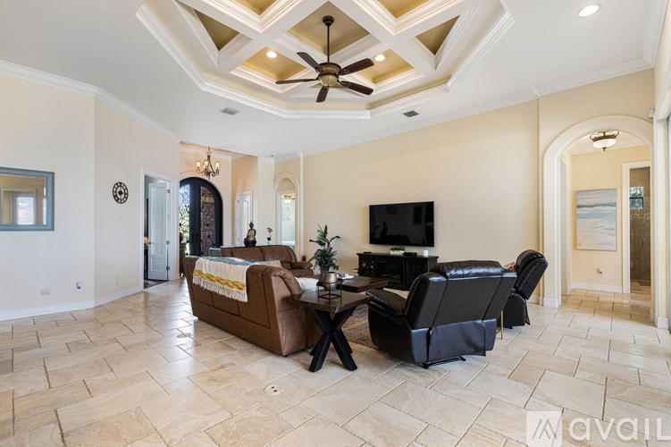 A living room with a brown couch, a black chair, and a television.