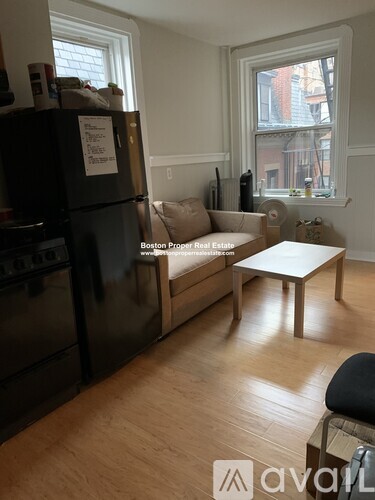 A kitchen with a black fridge and a white table.