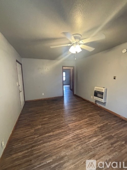 A room with wooden floors and a ceiling fan.