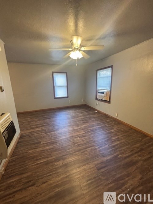 A room with wooden flooring and a ceiling fan.
