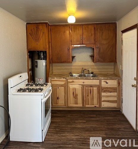 A small kitchen with wooden cabinets and a white stove.