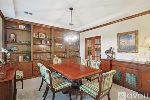 A dining room with a wooden table and chairs.