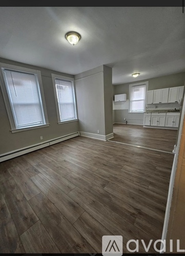 A room with wooden flooring and white walls.