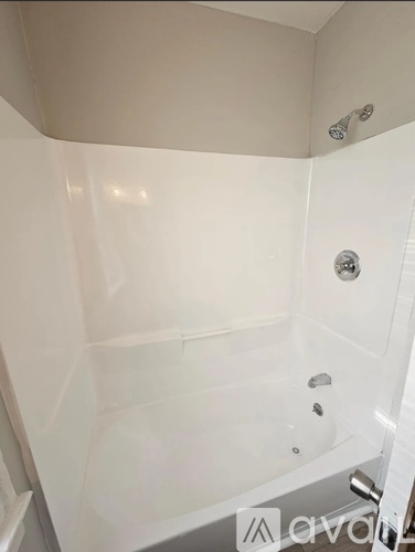 A white bathroom with a shower and a glass door.