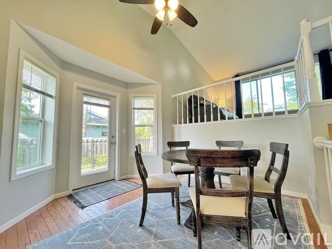 A dining room with a wooden table and chairs.