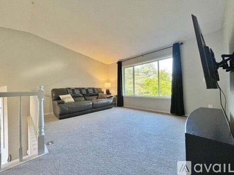 A living room with a grey sofa and a television.