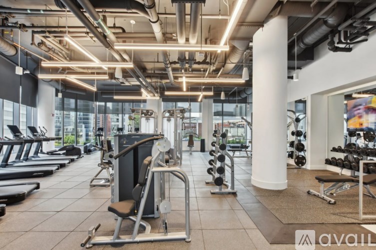 A gym with a variety of equipment including treadmills, weights, and exercise machines.