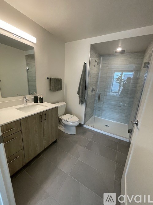 A bathroom with a toilet, sink, and shower.