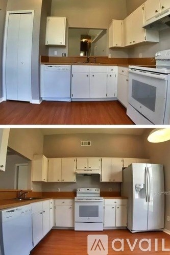 A kitchen with white appliances and wooden floors.