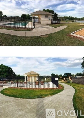 A pool area with a fence and a building in the background.