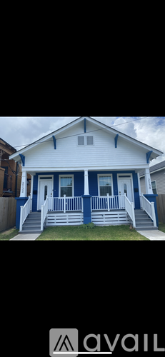 A white house with blue trim and a porch.