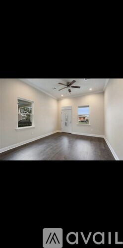 A room with a ceiling fan and a door.
