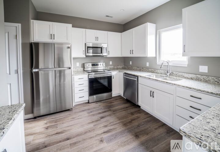 A kitchen with a stainless steel refrigerator, oven, and microwave.
