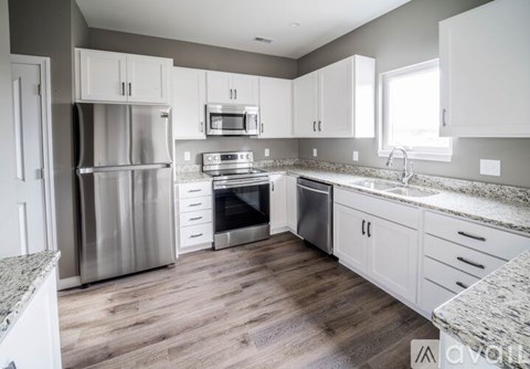 A kitchen with a stainless steel refrigerator, oven, and microwave.