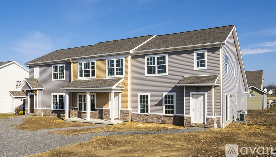 A two-story house with a grey exterior and white trim is available for purchase.