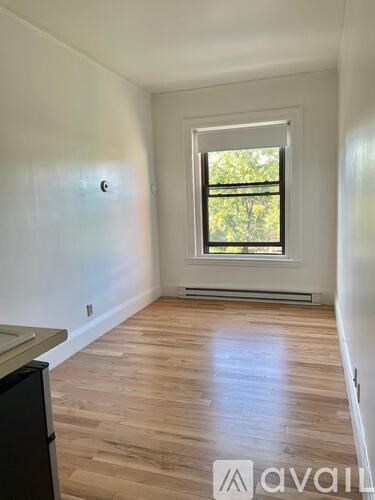 A room with wooden flooring and a window.