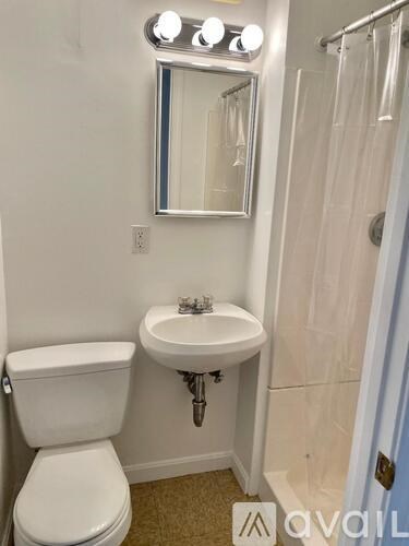 A white toilet sits next to a sink in a small bathroom.