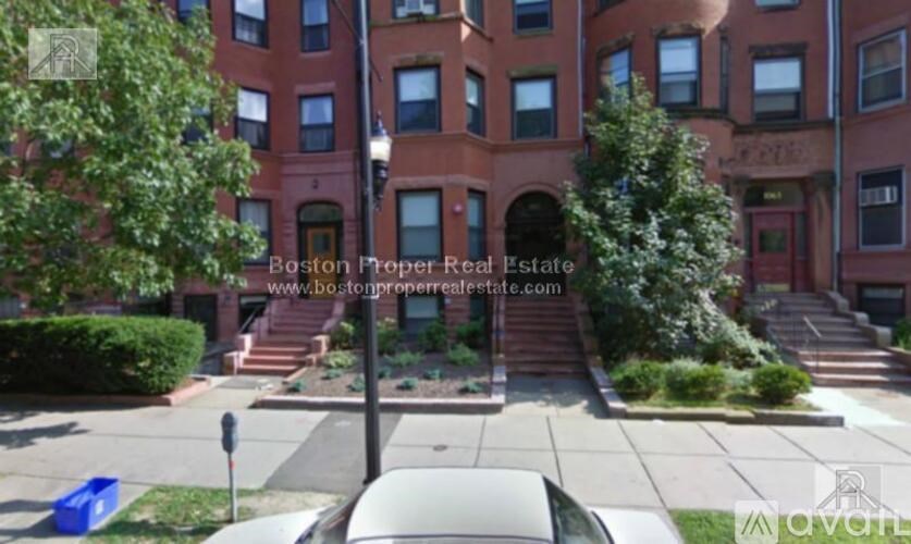 A red brick building with a tree in front of it.