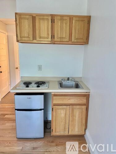 A kitchen with wooden cabinets and a white fridge.