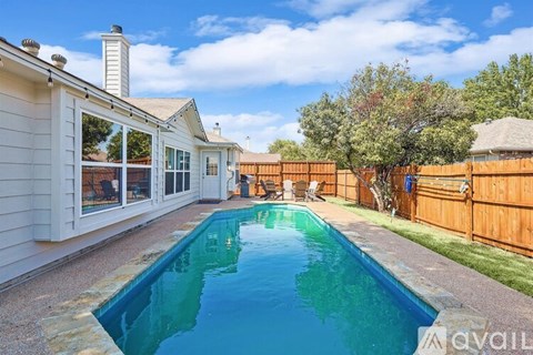 A backyard with a pool and a house.
