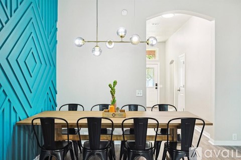 A dining room with a wooden table and chairs.