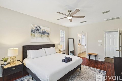 A bedroom with a large bed and a ceiling fan.